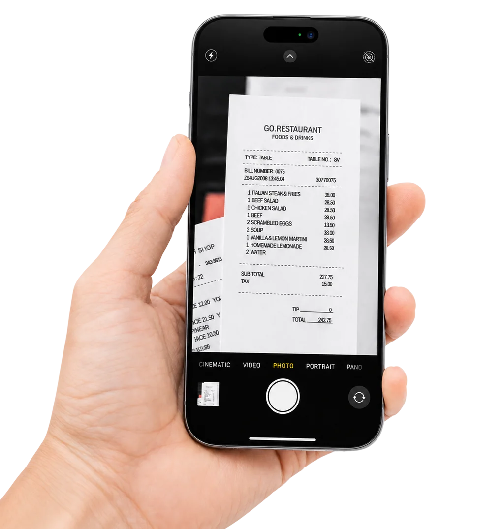 A hand holding an iPhone in camera mode, photographing a restaurant receipt